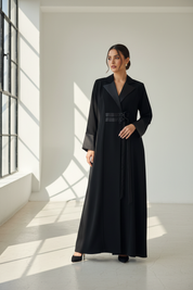 Arab model in black coat-style abaya in sunlit studio