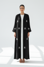 Arab model wearing black abaya with white embroidery - Image 1