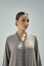 Close-up of Arab model in taupe abaya with silver beading